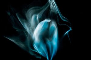 Fotografia artística de fum abstracte, fum en forma de cor de color blau sobre fons negre